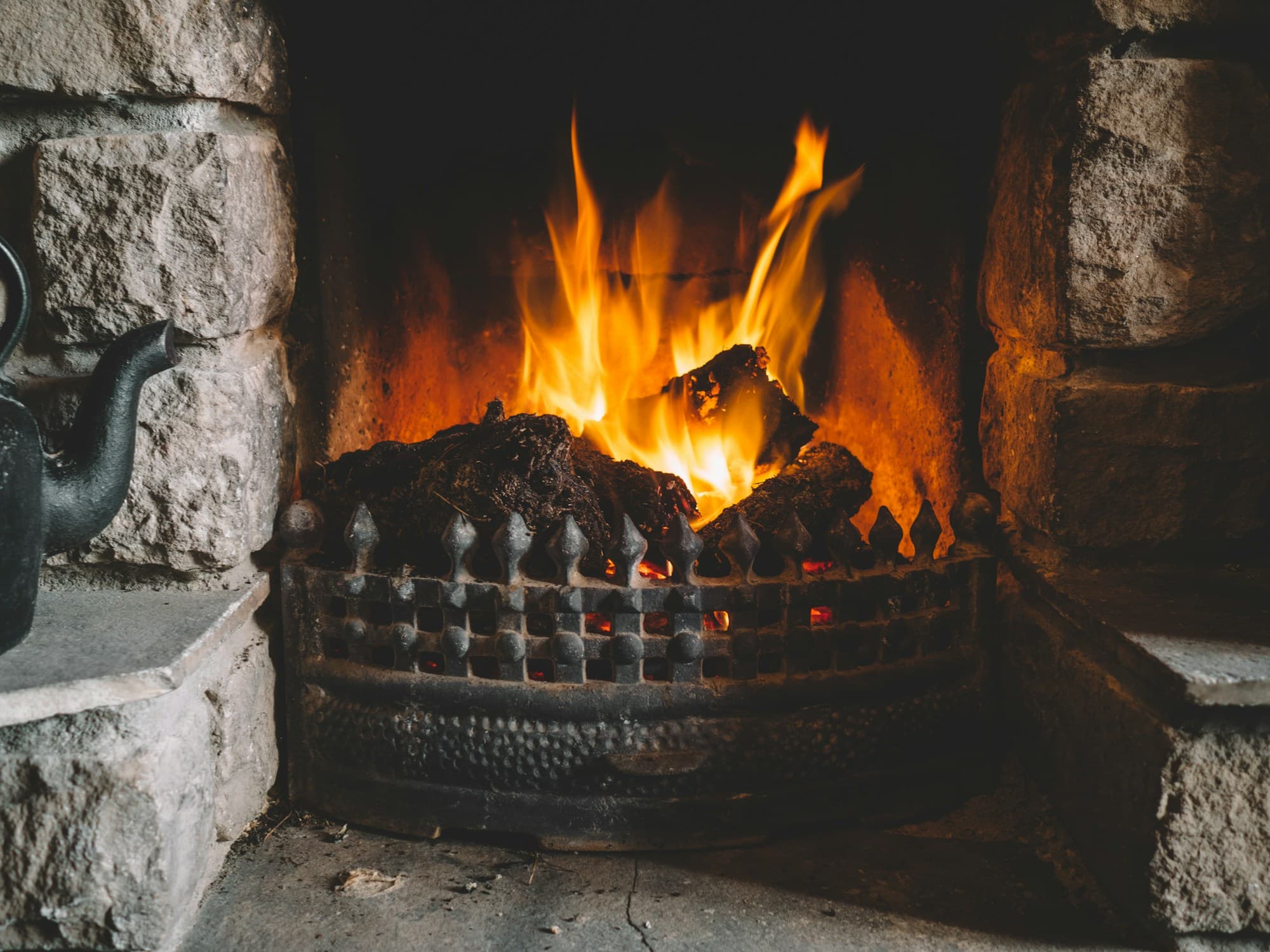 Fire burning in a traditional stone fireplace in Ireland